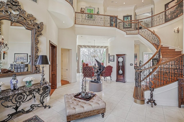 entrance foyer with a high ceiling, baseboards, stairs, tile patterned floors, and crown molding