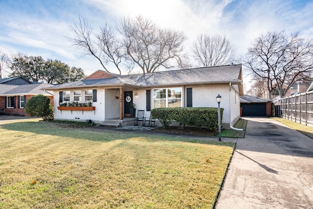 ranch-style house with a front yard, a garage, and an outbuilding