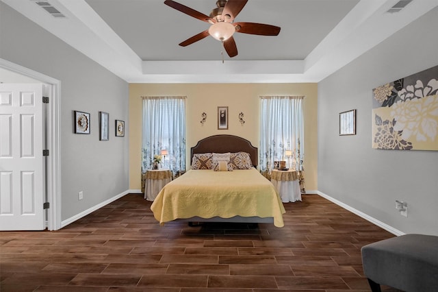 bedroom featuring ceiling fan and a raised ceiling