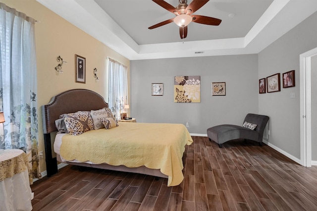 bedroom with ceiling fan and a tray ceiling