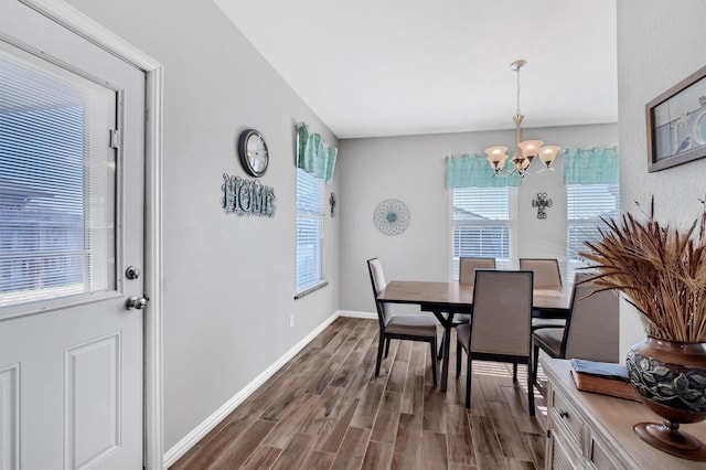 dining area with dark hardwood / wood-style floors and an inviting chandelier