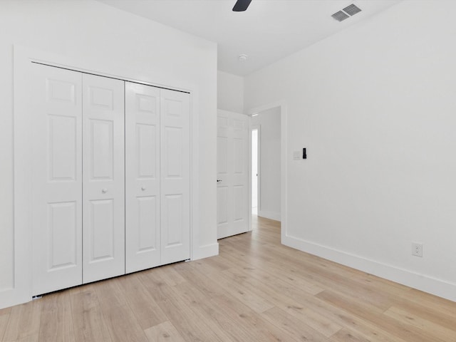 unfurnished bedroom featuring baseboards, visible vents, ceiling fan, light wood-type flooring, and a closet