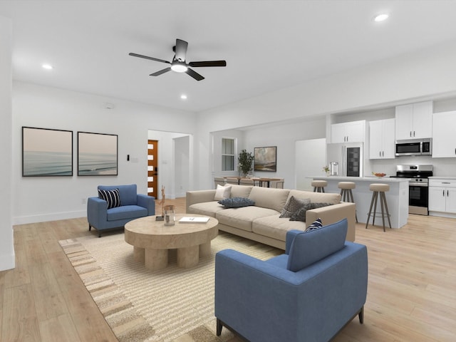 living room featuring light wood-style flooring, baseboards, a ceiling fan, and recessed lighting