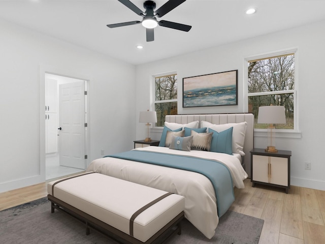 bedroom featuring light wood-style floors, multiple windows, and baseboards