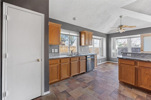 kitchen with lofted ceiling, stainless steel dishwasher, plenty of natural light, and sink