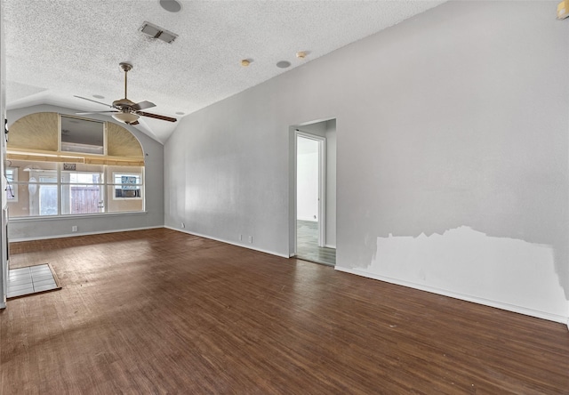 unfurnished living room with lofted ceiling, ceiling fan, dark hardwood / wood-style floors, and a textured ceiling