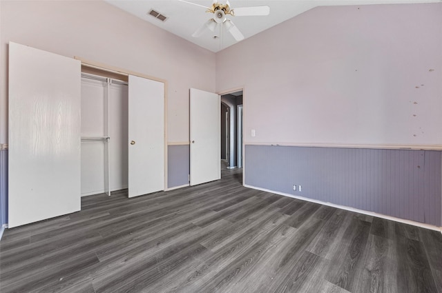 unfurnished bedroom with lofted ceiling, ceiling fan, a closet, and dark hardwood / wood-style floors