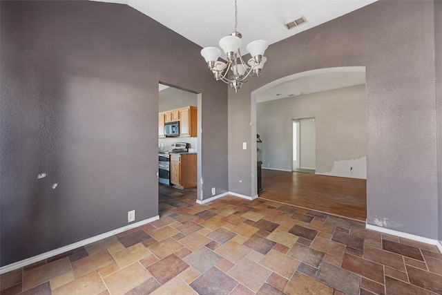 unfurnished room featuring lofted ceiling and a notable chandelier