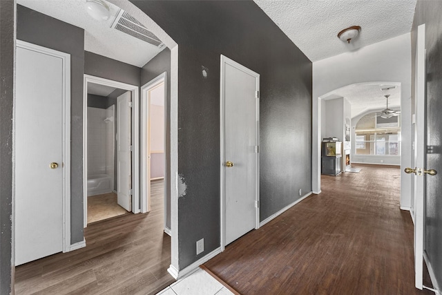 hall with dark wood-type flooring and a textured ceiling