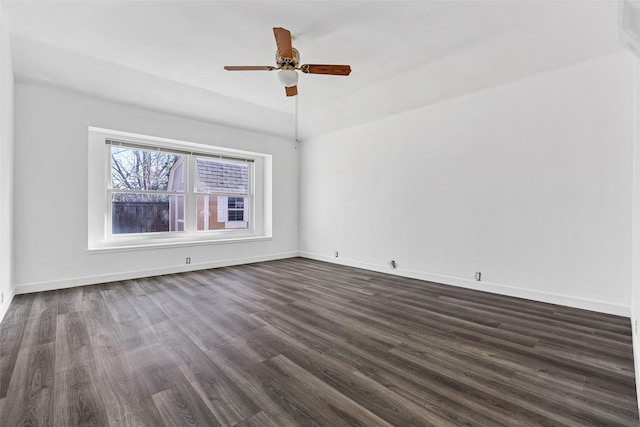 spare room with ceiling fan, dark wood-type flooring, and vaulted ceiling