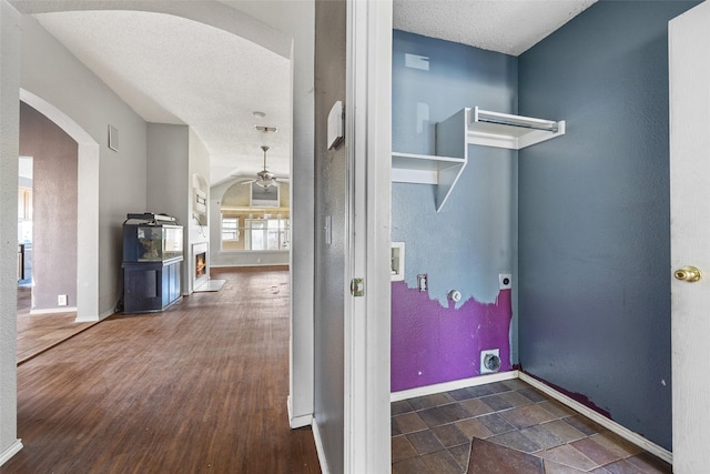 laundry area with ceiling fan, electric dryer hookup, and a textured ceiling