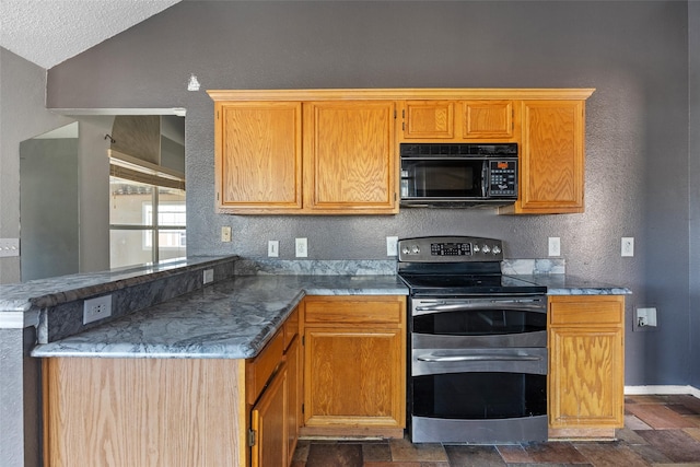 kitchen featuring a textured ceiling, lofted ceiling, kitchen peninsula, and range with two ovens