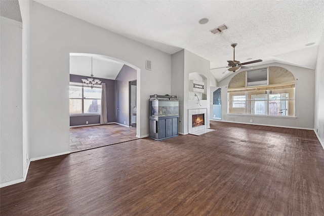 unfurnished living room with a textured ceiling, lofted ceiling, ceiling fan with notable chandelier, and dark hardwood / wood-style floors