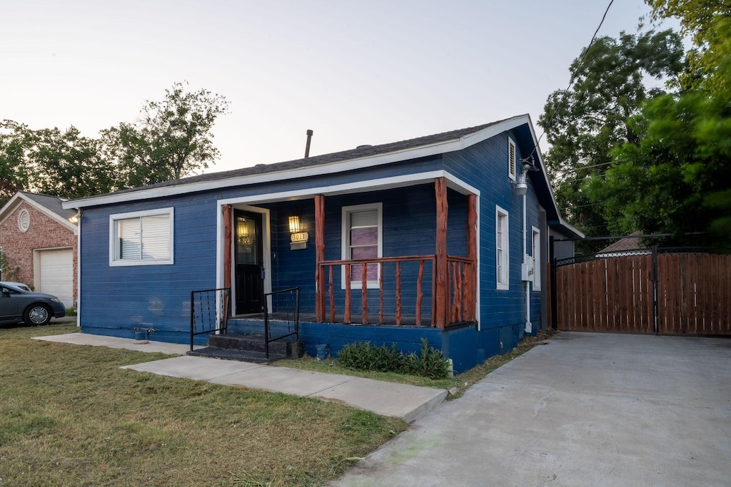 view of front of house with a garage, a porch, and a front yard