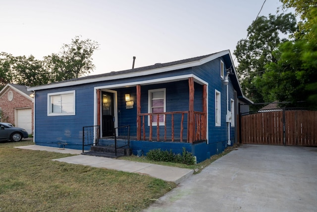 view of front of house with a garage, a porch, and a front yard