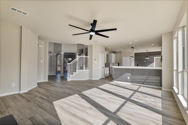 unfurnished living room featuring ceiling fan and light hardwood / wood-style flooring