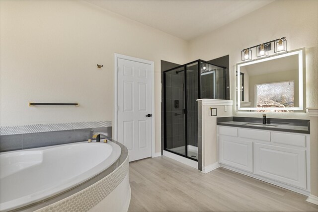 bathroom with vanity, wood-type flooring, and plus walk in shower