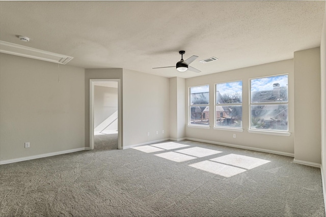 spare room featuring ceiling fan, carpet, and a textured ceiling