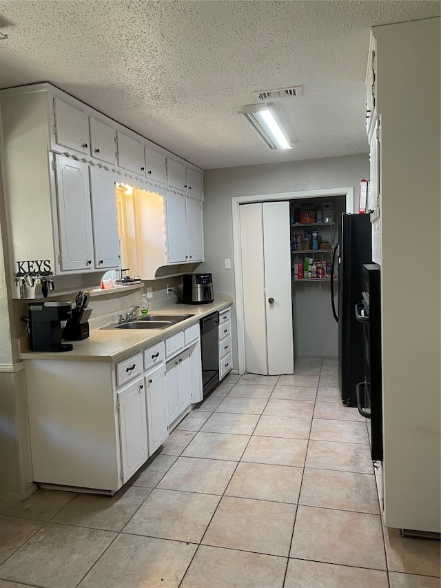 kitchen featuring sink, white cabinetry, black dishwasher, and a textured ceiling