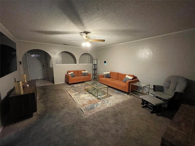 carpeted living room with ceiling fan, ornamental molding, and a textured ceiling