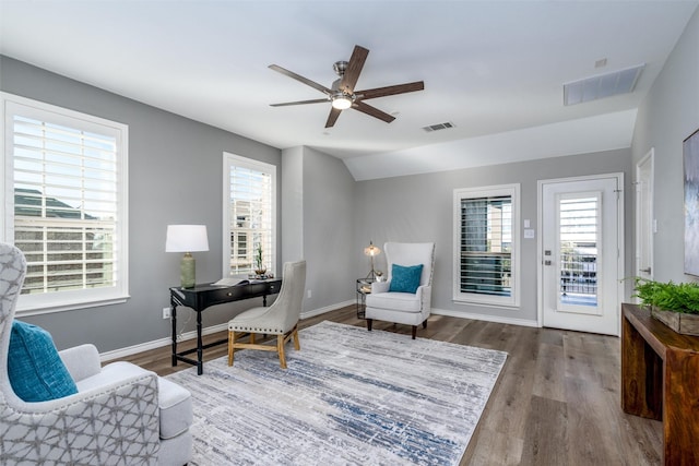 living area featuring ceiling fan, hardwood / wood-style floors, lofted ceiling, and plenty of natural light