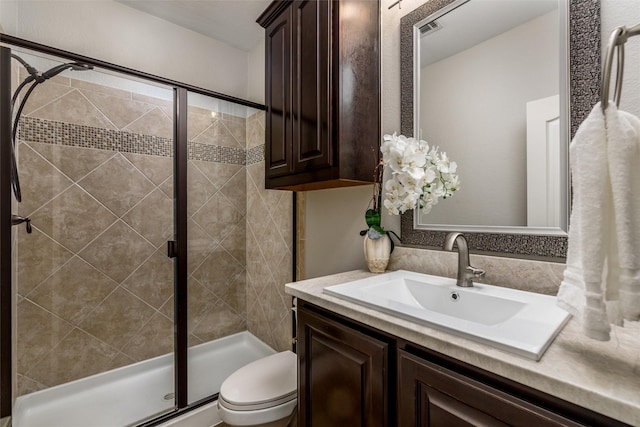 bathroom with toilet, an enclosed shower, and vanity