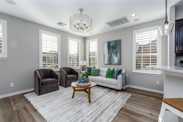 living room featuring a wealth of natural light, a chandelier, and dark hardwood / wood-style floors