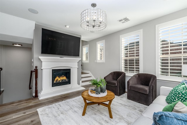 living room featuring wood-type flooring and an inviting chandelier