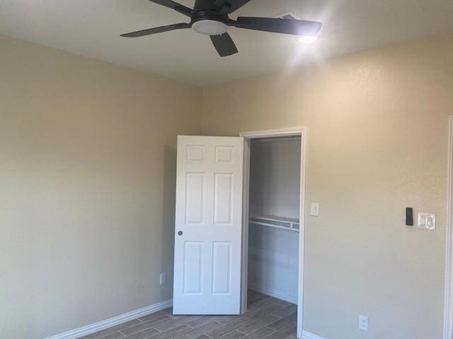 unfurnished bedroom with wood finish floors, a closet, ceiling fan, and baseboards