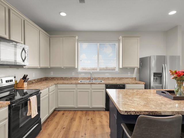 kitchen featuring light wood-type flooring, sink, white cabinets, and black appliances