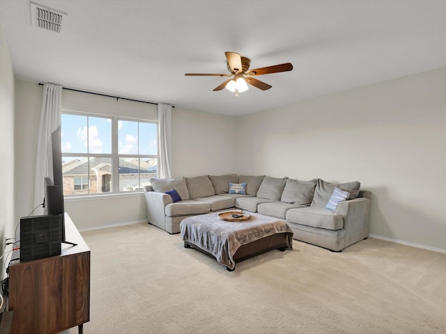 carpeted living room with ceiling fan and a water view