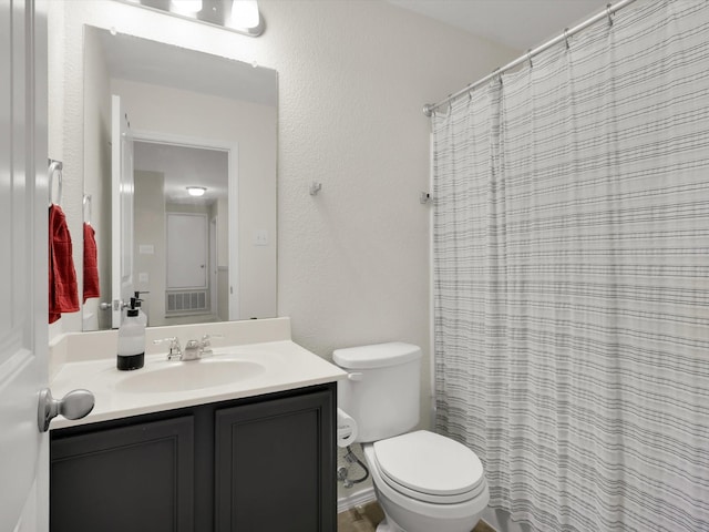 bathroom with toilet, vanity, and curtained shower