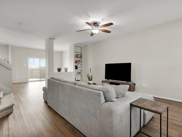 living room with ceiling fan, built in features, and hardwood / wood-style floors