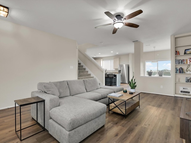 living room featuring ceiling fan and dark wood-type flooring