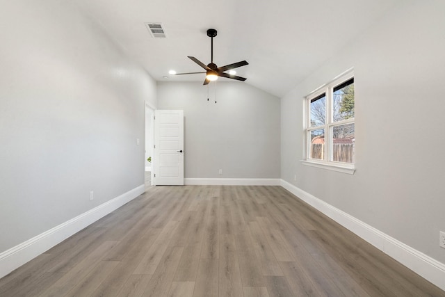 empty room featuring ceiling fan, vaulted ceiling, and light hardwood / wood-style floors