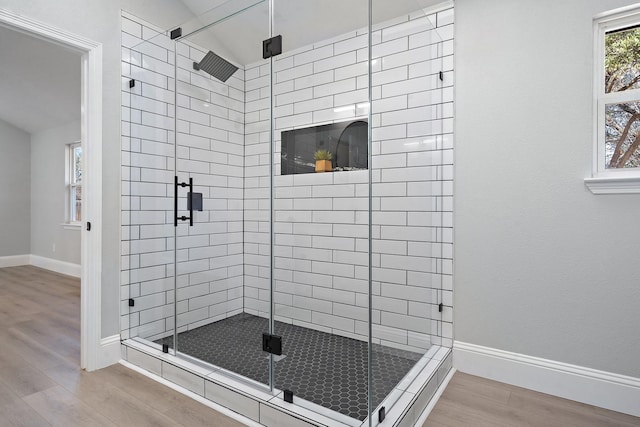 bathroom with wood-type flooring and a shower with door