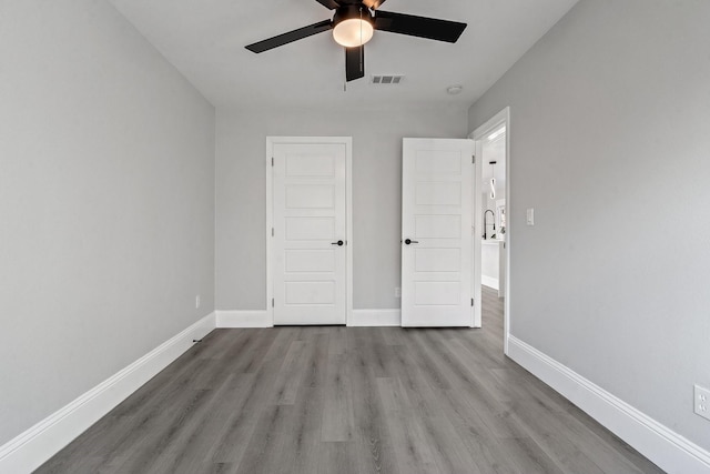 unfurnished bedroom with light wood-type flooring, ceiling fan, and a closet