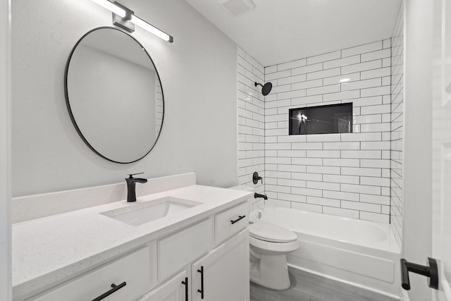 full bathroom featuring toilet, tiled shower / bath combo, vanity, and hardwood / wood-style flooring