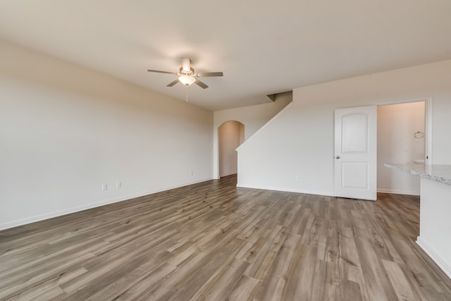 unfurnished living room featuring ceiling fan and wood-type flooring