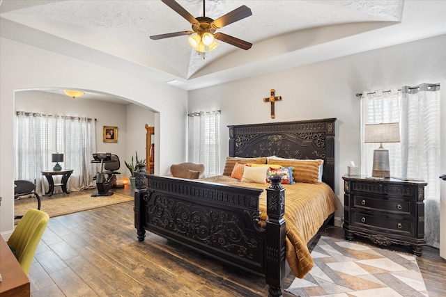 bedroom with ceiling fan, lofted ceiling, wood-type flooring, and multiple windows