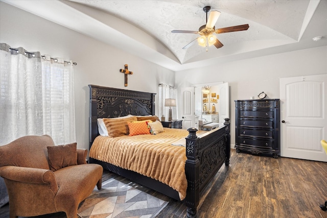 bedroom featuring ceiling fan, dark hardwood / wood-style flooring, and a raised ceiling