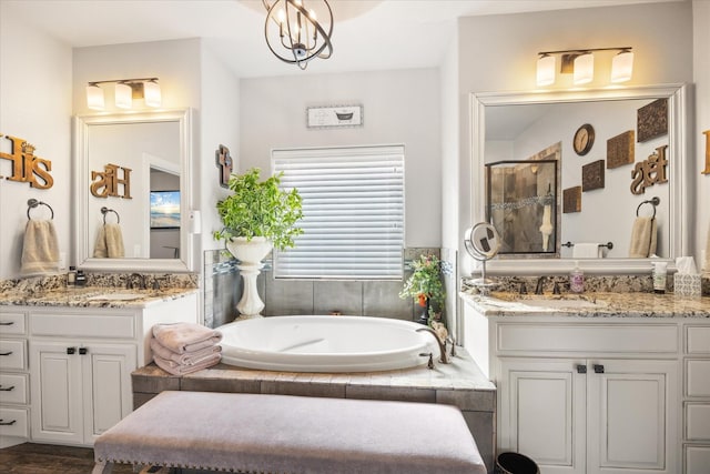 bathroom with separate shower and tub, vanity, and a notable chandelier