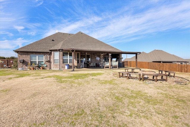 back of house featuring a patio area, an outdoor fire pit, and a lawn