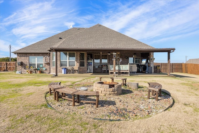 back of property featuring a patio area, an outdoor fire pit, and a yard