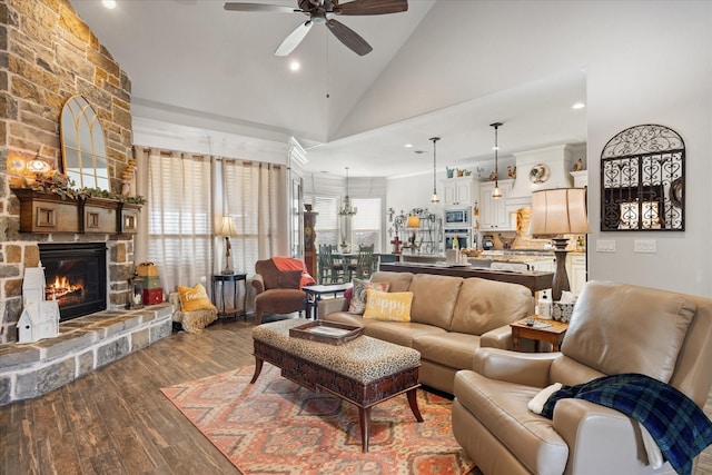 living room featuring high vaulted ceiling, wood-type flooring, ceiling fan, and a fireplace