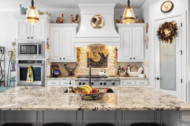 kitchen with appliances with stainless steel finishes, white cabinetry, decorative backsplash, light stone counters, and custom range hood