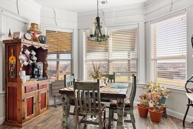 dining room featuring an inviting chandelier, wood-type flooring, plenty of natural light, and crown molding