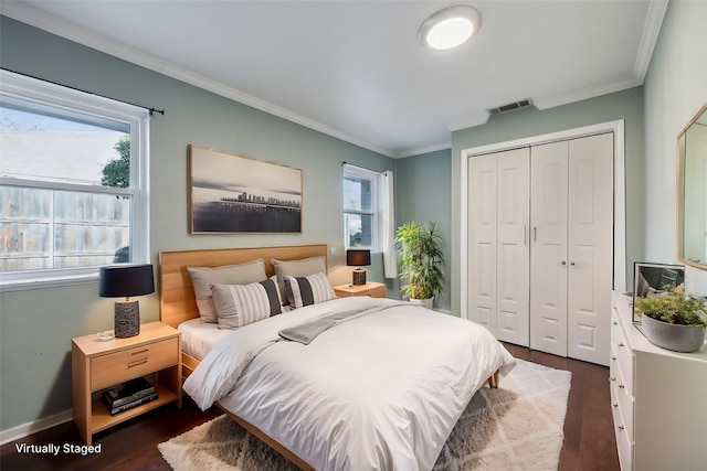 bedroom featuring a closet, dark hardwood / wood-style flooring, and ornamental molding