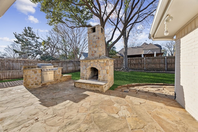 view of patio with area for grilling, exterior kitchen, and an outdoor stone fireplace