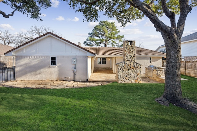 back of property featuring a lawn and area for grilling